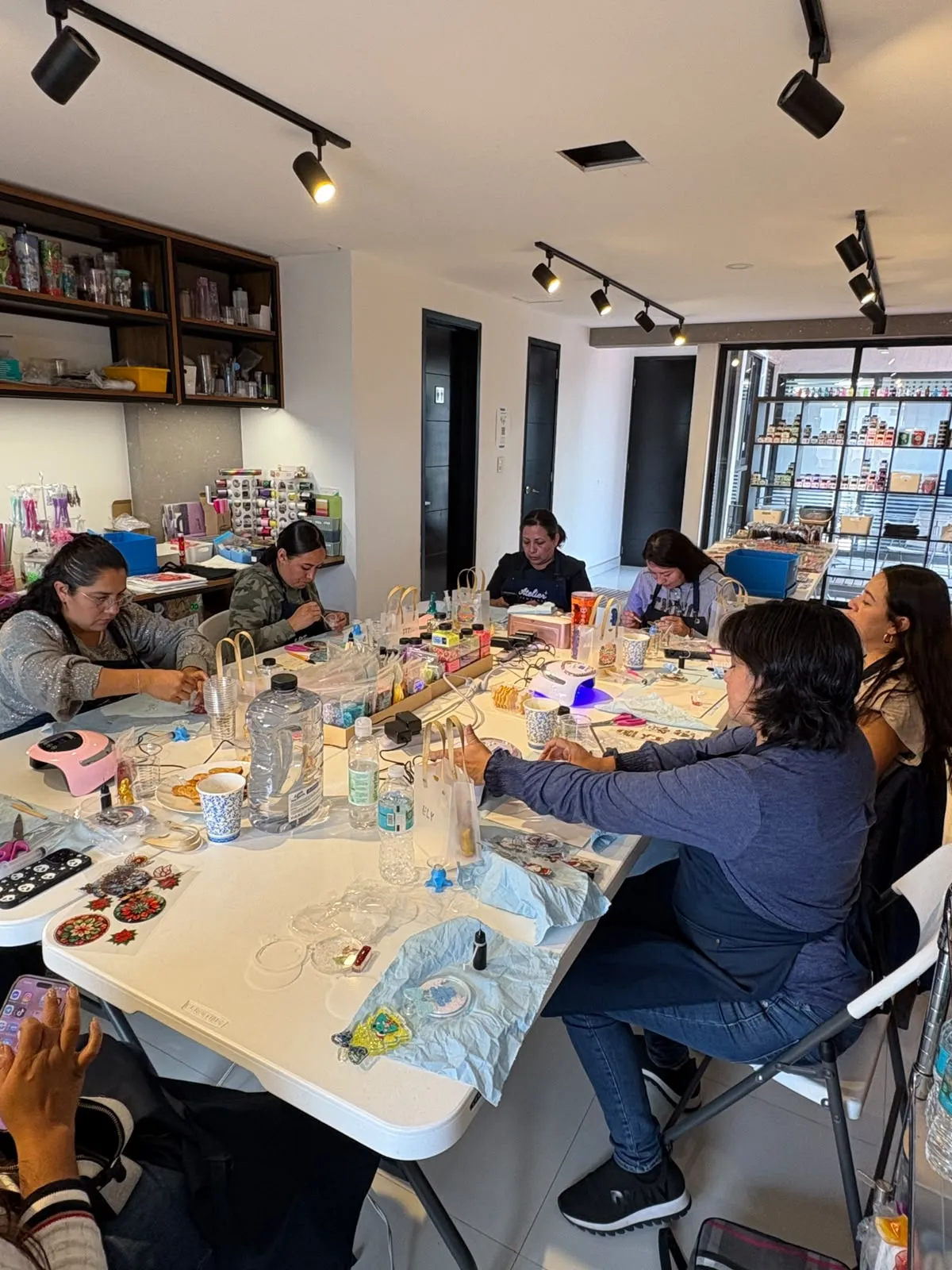 Alumnas armando snow globes en una mesa de nuestro estudio